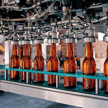 Glass bottles move through a beverage manufacturing plant. Monitoring dissolved oxygen is important to managing product quality.