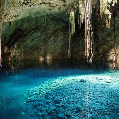 A turquoise pool of water shimmers in a cave. Groundwater sources are often prone to nitrate due to surface water.