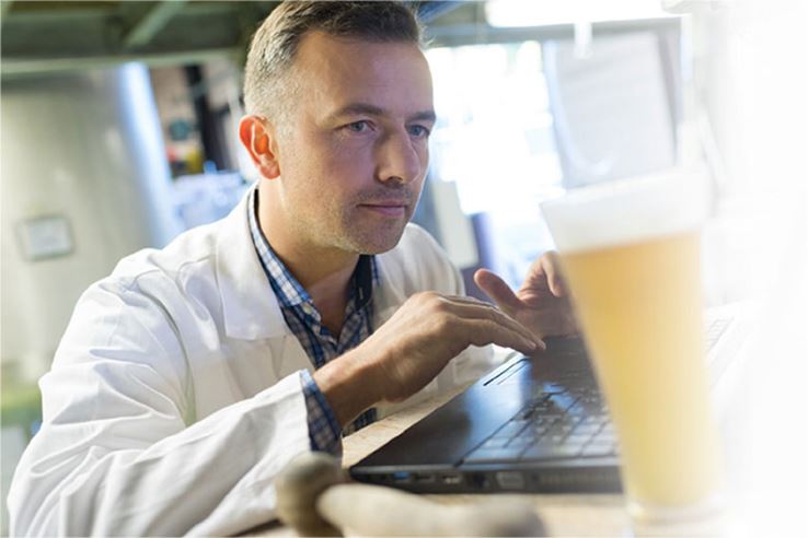 Brewing chemist working on a computer.